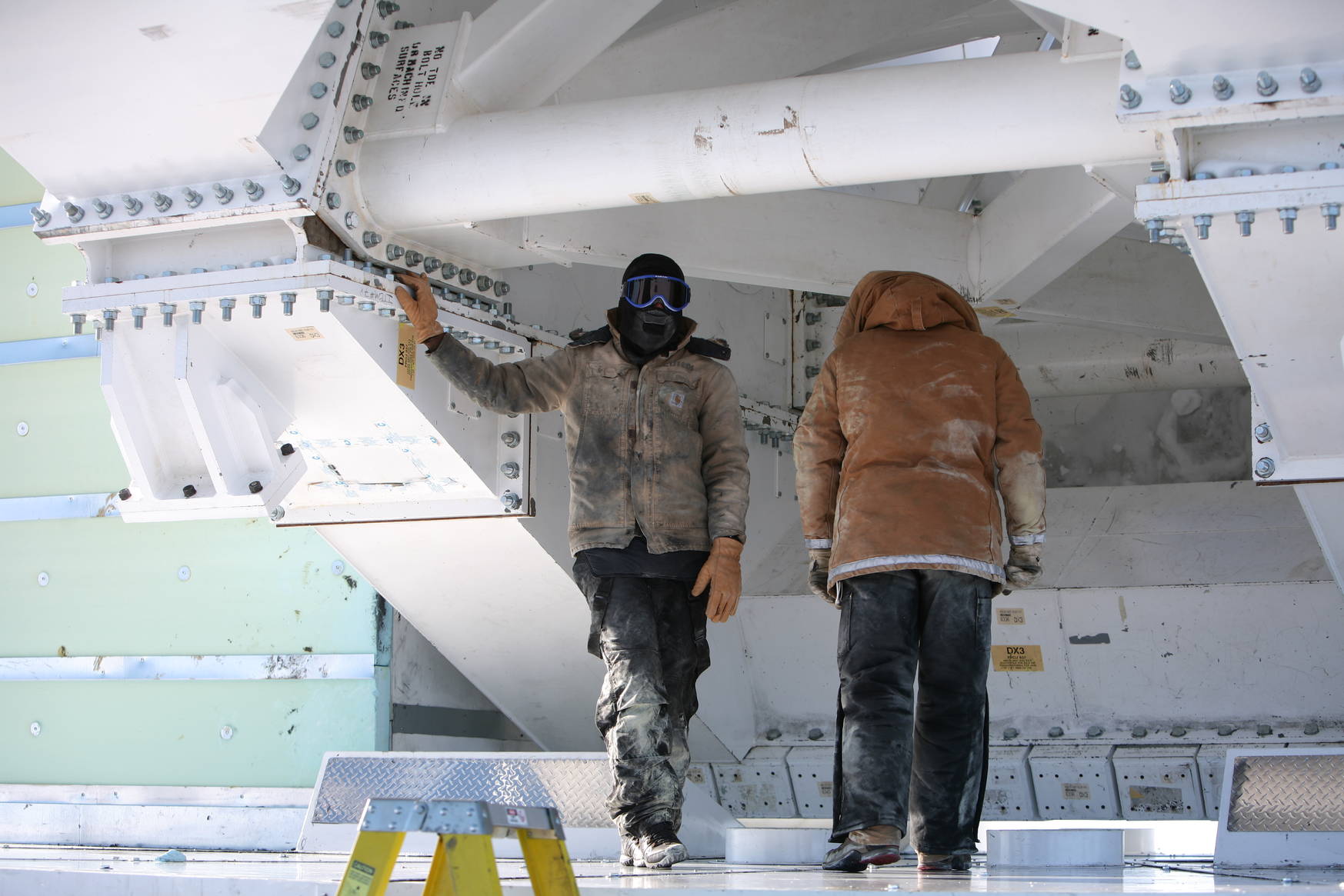 Two SPT colleagues at the base of/underneath the telescope. It's cold working outside on a metal structure, proper clothing is important.