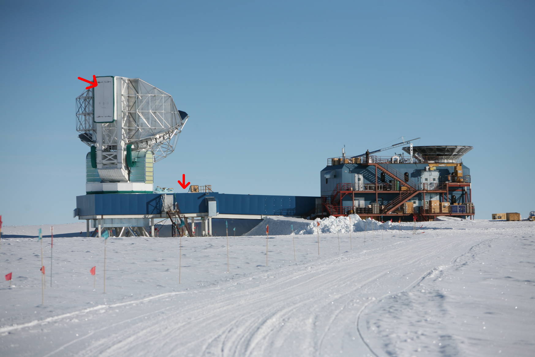 To access the receiver cabin there are doors in its floor (left-hand side arrow). The telescope is pointing straight up in the picture, which makes it difficult to access the doors. If one actually wants to get into the receiver cabin the telescope is moved to a horizontal position, so that the receiver cabin is on top of the building roof (right-hand side red arrow). The roof opens up providing direct access from the building into the receiver cabin.