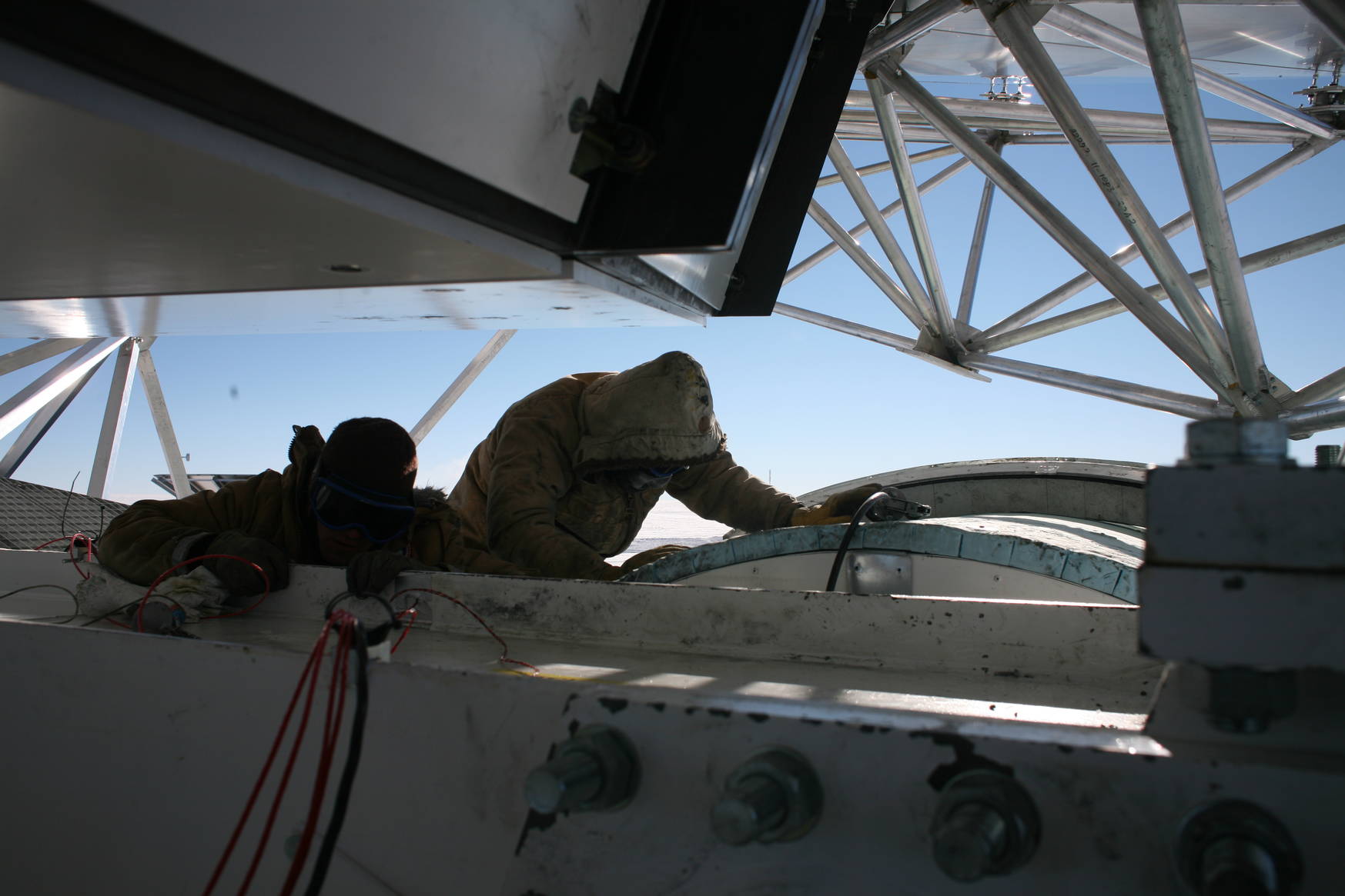 From inside the telescope mount: Two SPT colleagues greasing the elevation bearing.